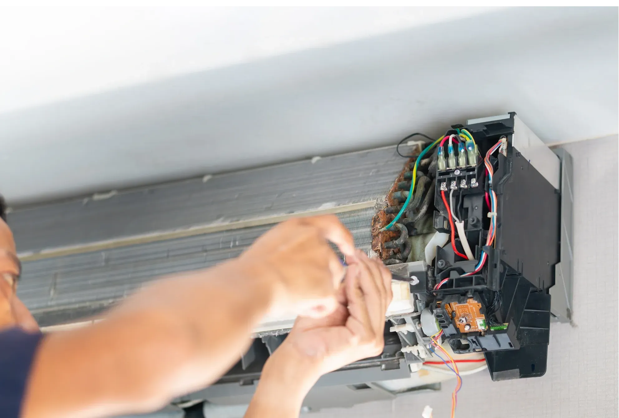 Teknisi memasang ulang papan sirkuit unit AC indoor