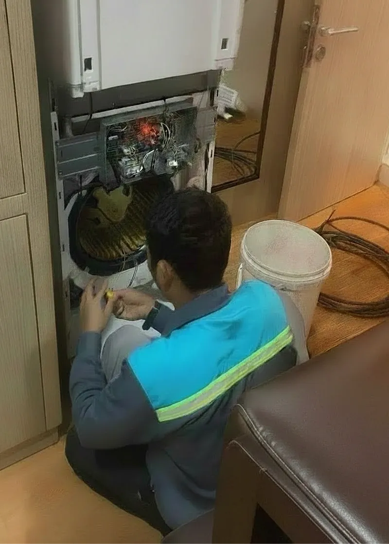 Teknisi memeriksa panel kelistrikan unit AC